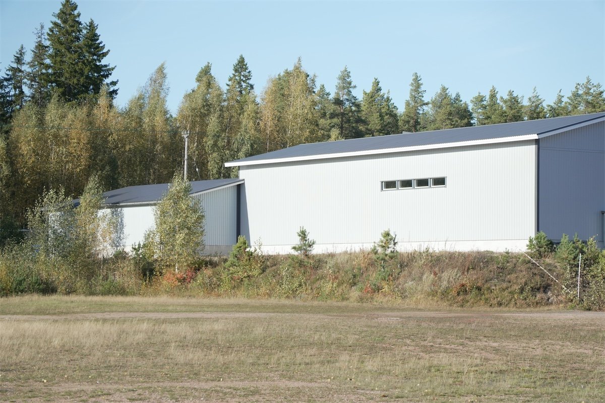 Venehallin rakennus metsän reunassa syksyisessä maisemassa